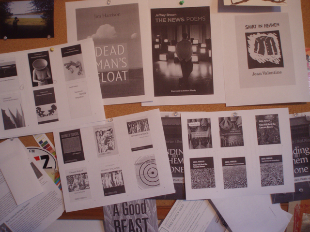 Bulletin board wit lots of cover designs printed and posted all over it.